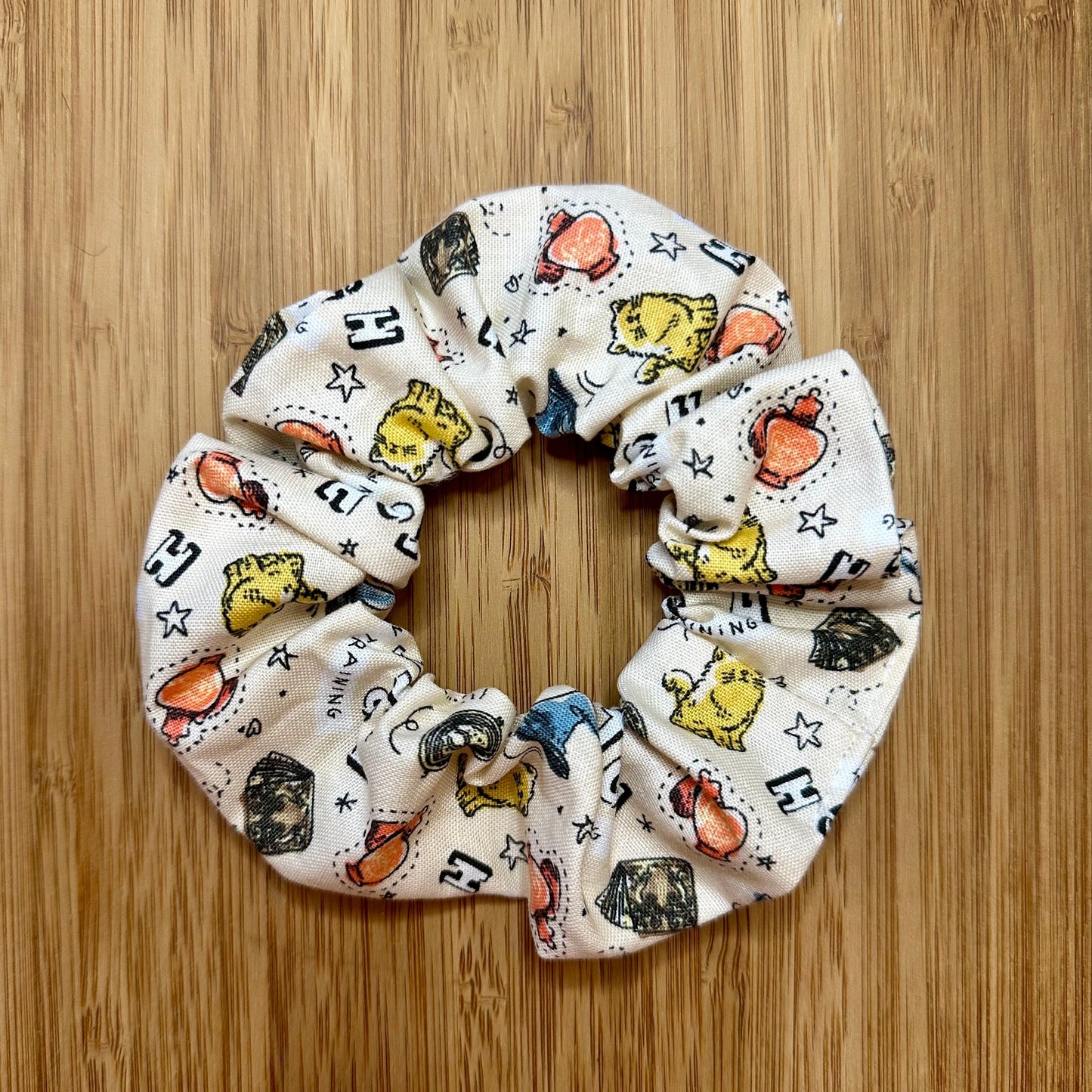 Beige scrunchie with witch patterns (cats, magic potion, books, etc.)