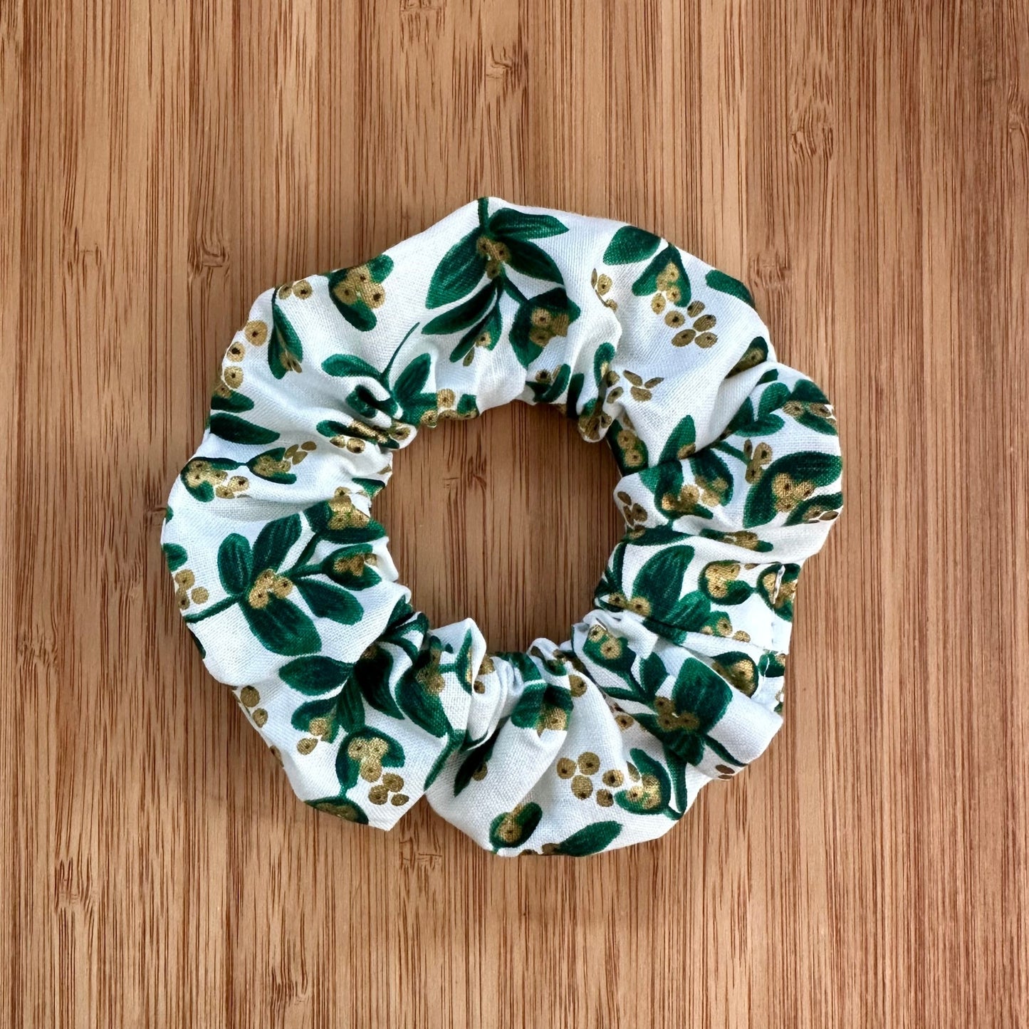 White scrunchie with green and gold leaves